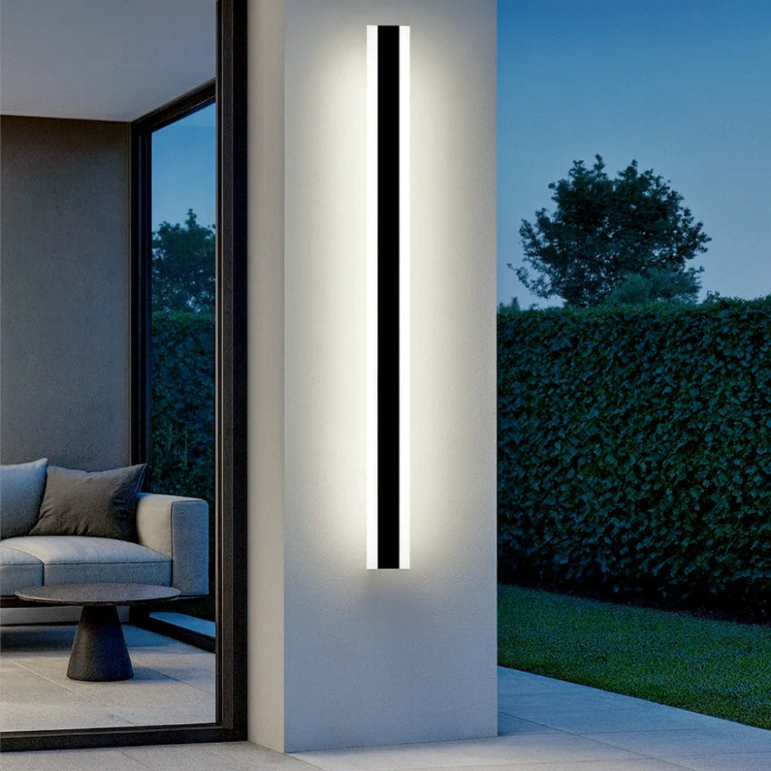 Waterproof outdoor long LED wall light illuminating a contemporary porch at night