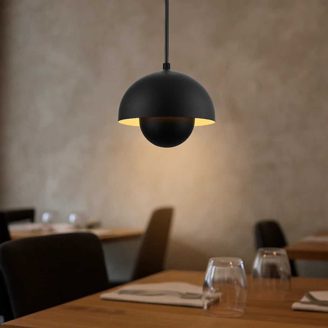Black double-shade pendant light in an interior with dark wood furniture