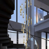Gold teardrop crystal chandelier installed beside a modern staircase