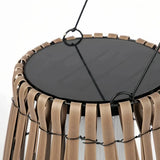 Close-up of the integrated solar panel and woven rattan frame on an outdoor floor lantern