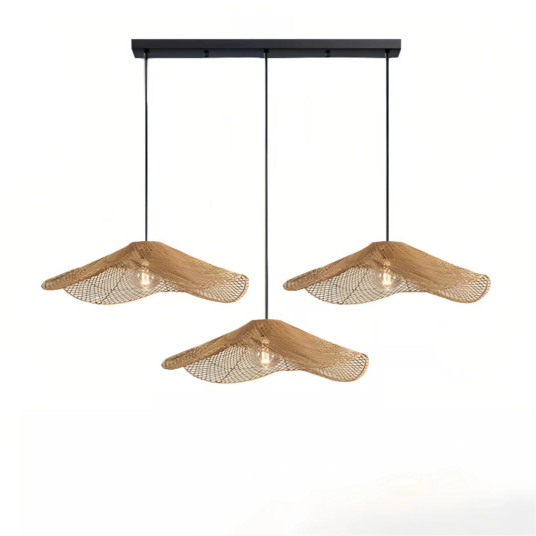 Three wave rattan pendant shades suspended from a black linear ceiling bar