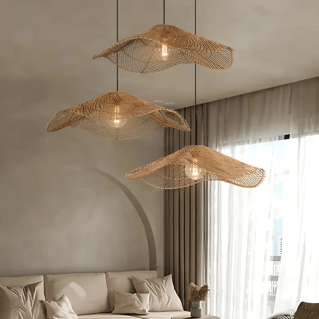 Three wave-shaped rattan pendant shades hanging at staggered heights above a pale sofa