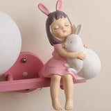 Close-up of the cartoon girl and rabbit resin detail on a children's wall light