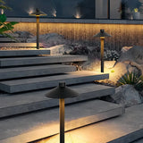 Black metal mushroom pathway light illuminating garden steps at night