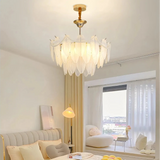 Glass feather chandelier above a bed beside a bay window