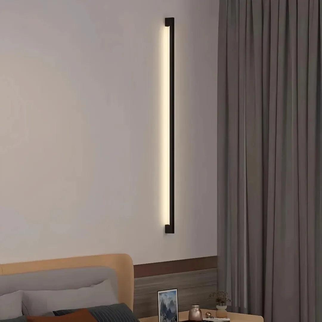 Minimalist black wall light used as ambient bedroom lighting
