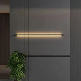 Dimmable black linear wall light mounted on a dark feature wall