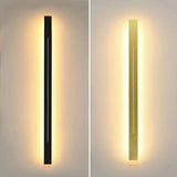 Black and gold linear LED wall lights casting warm light in a modern interior.