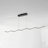 Black wave LED pendant light above a marble-effect dining table