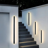 IP65 black wall light illuminating an exterior wall