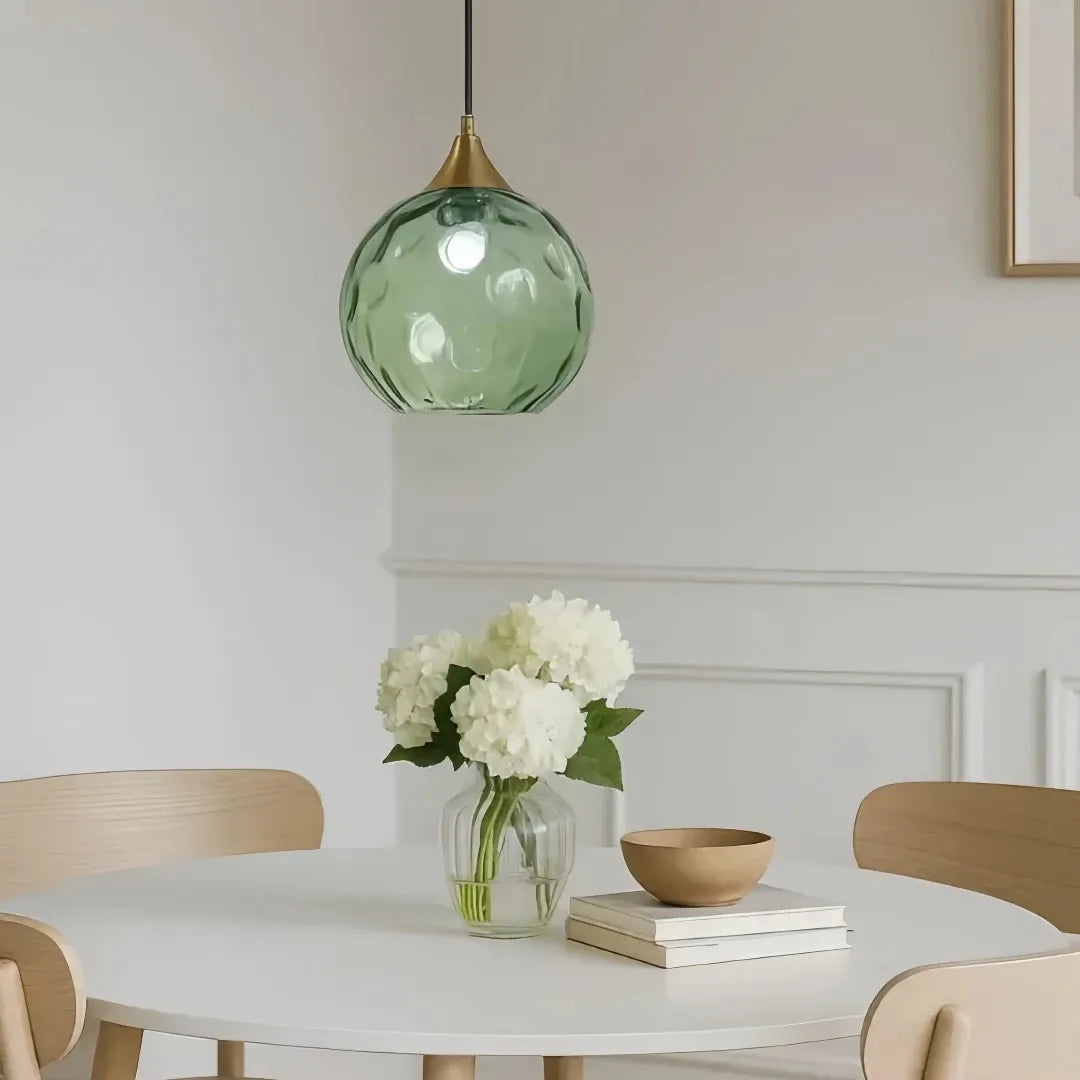 Contemporary dining room featuring a stylish coloured glass pendant light
