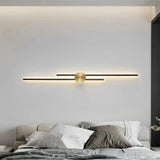 Black two-line linear LED wall light with a gold centre mount in a living room