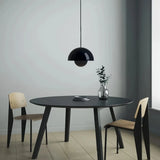 Black double-shade pendant light in an interior with dark wood furniture