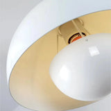 White double-shade pendant light suspended beside a bed