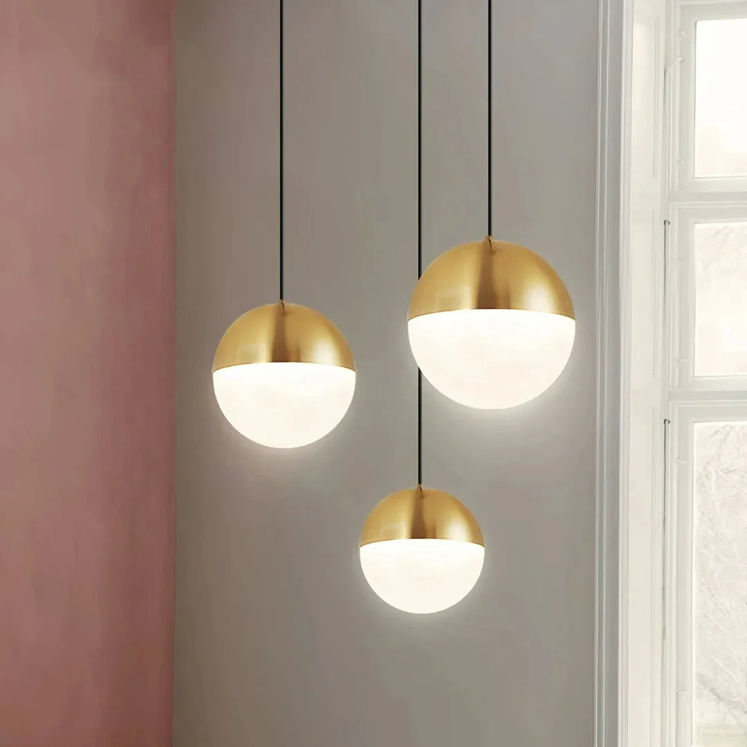 Gold-finish pendant light with a frosted glass globe shade