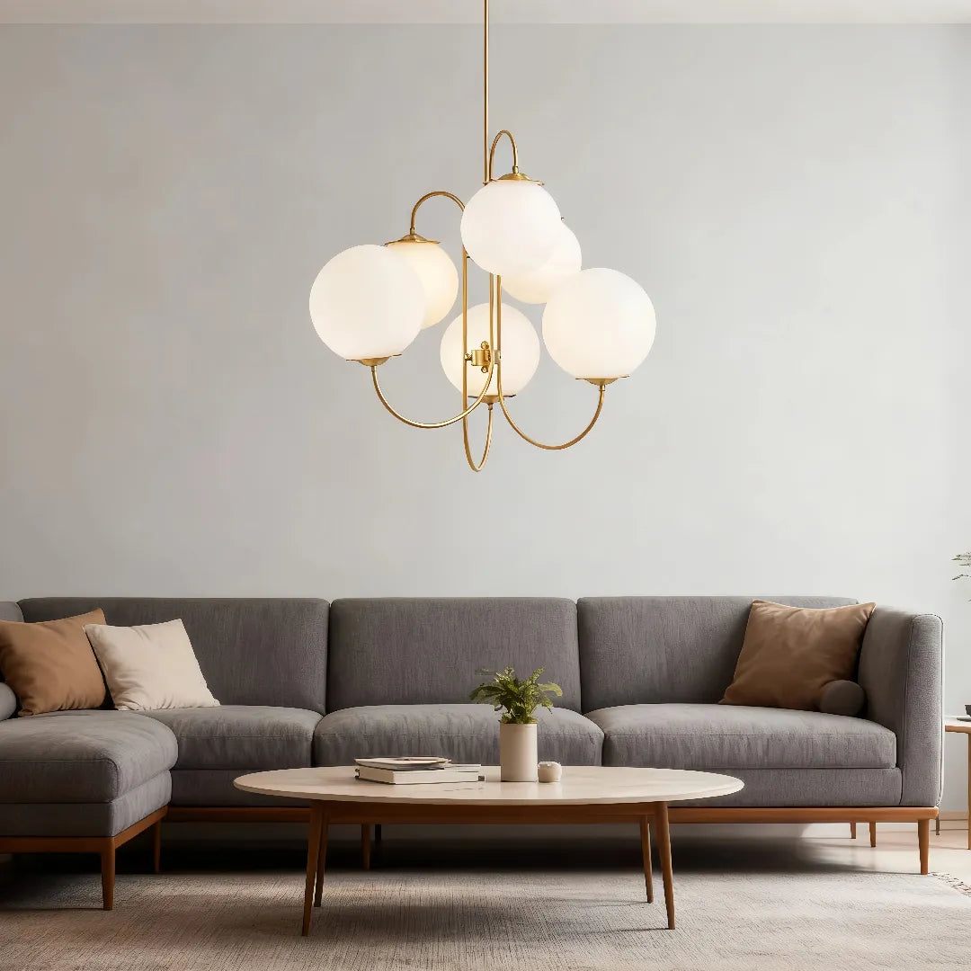 Globe chandelier above a coffee table in a living room with a grey sofa