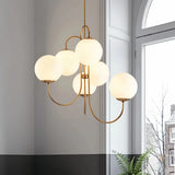 Six-light opal glass globe chandelier illuminated beside an arched window |