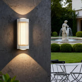 White outdoor up and down wall light casting warm light on an exterior wall