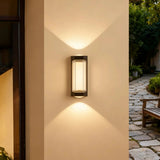 Black up and down wall light with warm lighting on a patio wall