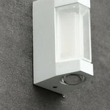 Close-up of the white wall light mounted on a textured exterior wall