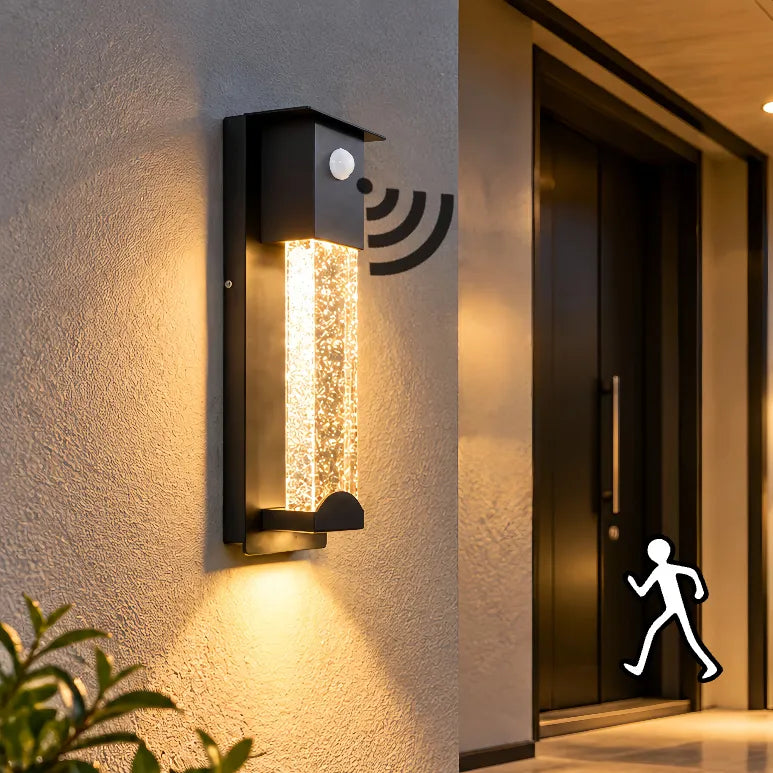 Black crystal glass outdoor wall light with motion sensor, shown illuminated in a rain scene