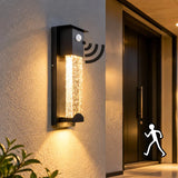 Black crystal glass outdoor wall light with motion sensor, shown illuminated in a rain scene
