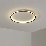 Black round flush ceiling light casting warm light over a bedroom