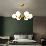 Gold 6-light chandelier with white glass globes in a bedroom