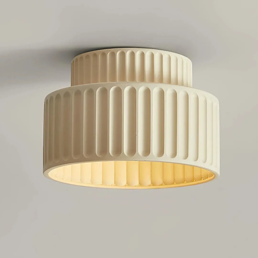 Underside view of a cream flush ceiling light with a ribbed shade