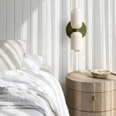 Opal glass wall light installed beside a bed in a bedroom