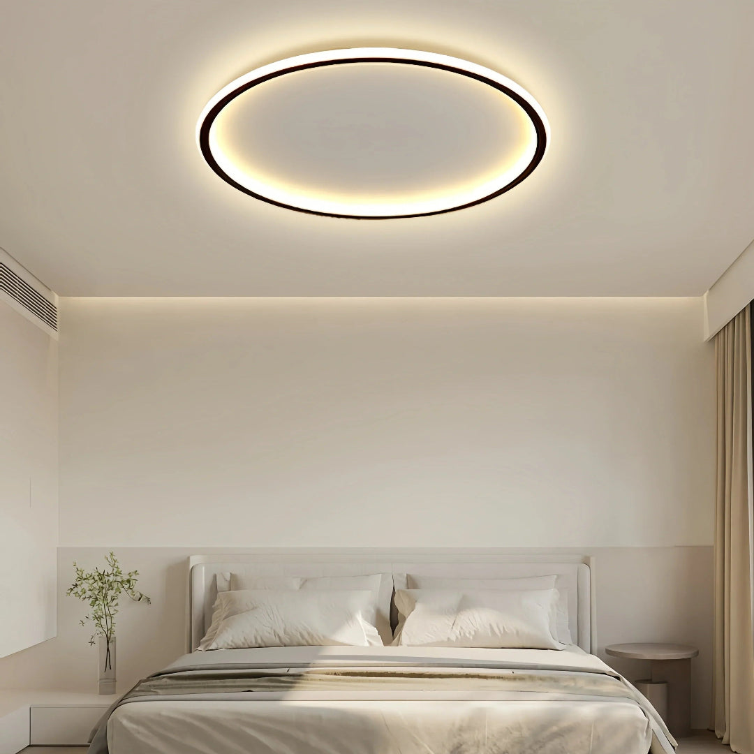 Round flush ceiling light with a dark rim and warm white glow