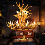 Brown faux antler chandelier lit above a coffee table
