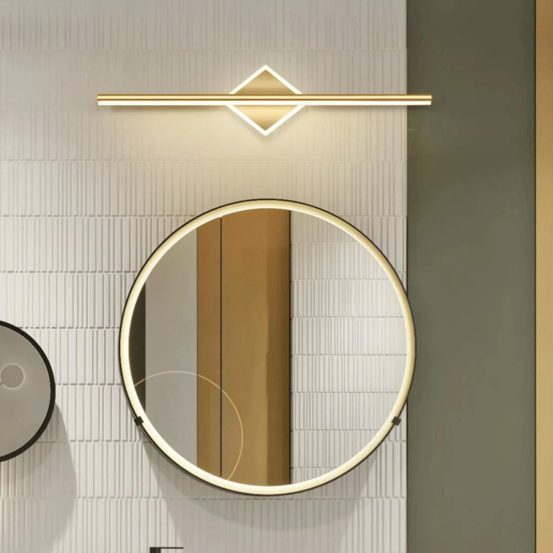 Gold round linear bathroom mirror light above a vanity mirror`