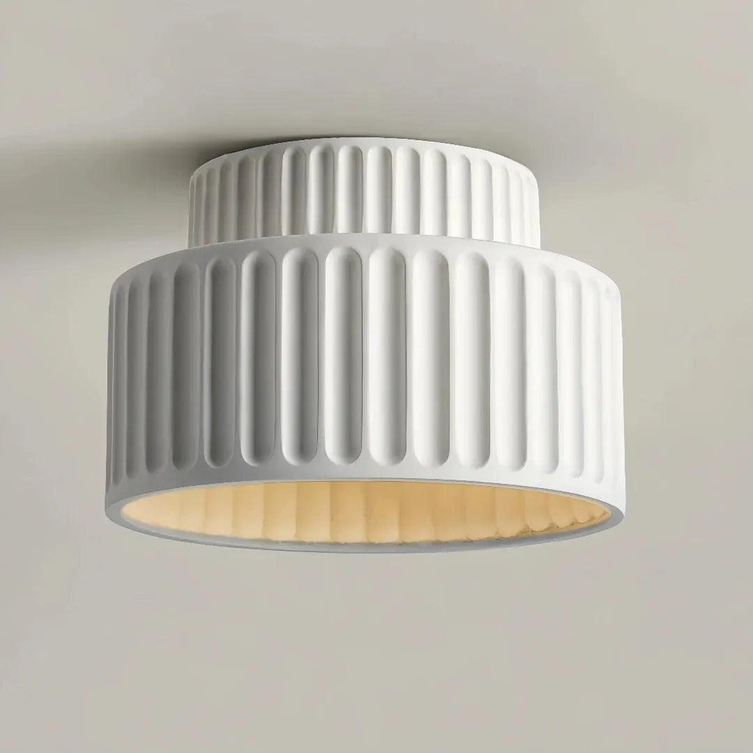 Underside view of a cream flush ceiling light with a ribbed shade