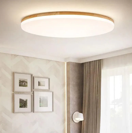 A modern bedroom ceiling light with a sleek circular design and wood trim, creating a warm and inviting ambiance in a stylish bedroom setting.
