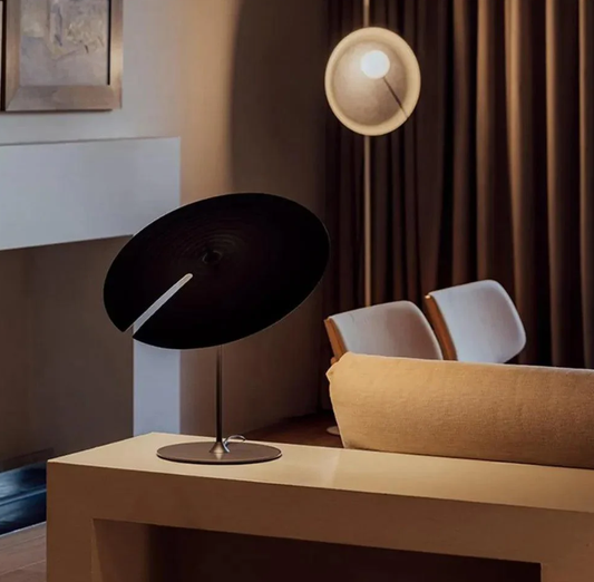 Warm modern living room with a sculptural black table lamp and soft ambient lighting, creating a stylish and cosy interior atmosphere.