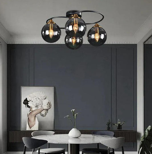 Modern black semi-flush ceiling light with smoked glass globes over a round dining table in a contemporary UK home, warm ambient glow.