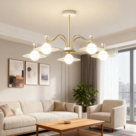 Modern brass chandelier with opal glass shades lighting a minimalist living room, providing warm, even ceiling illumination.