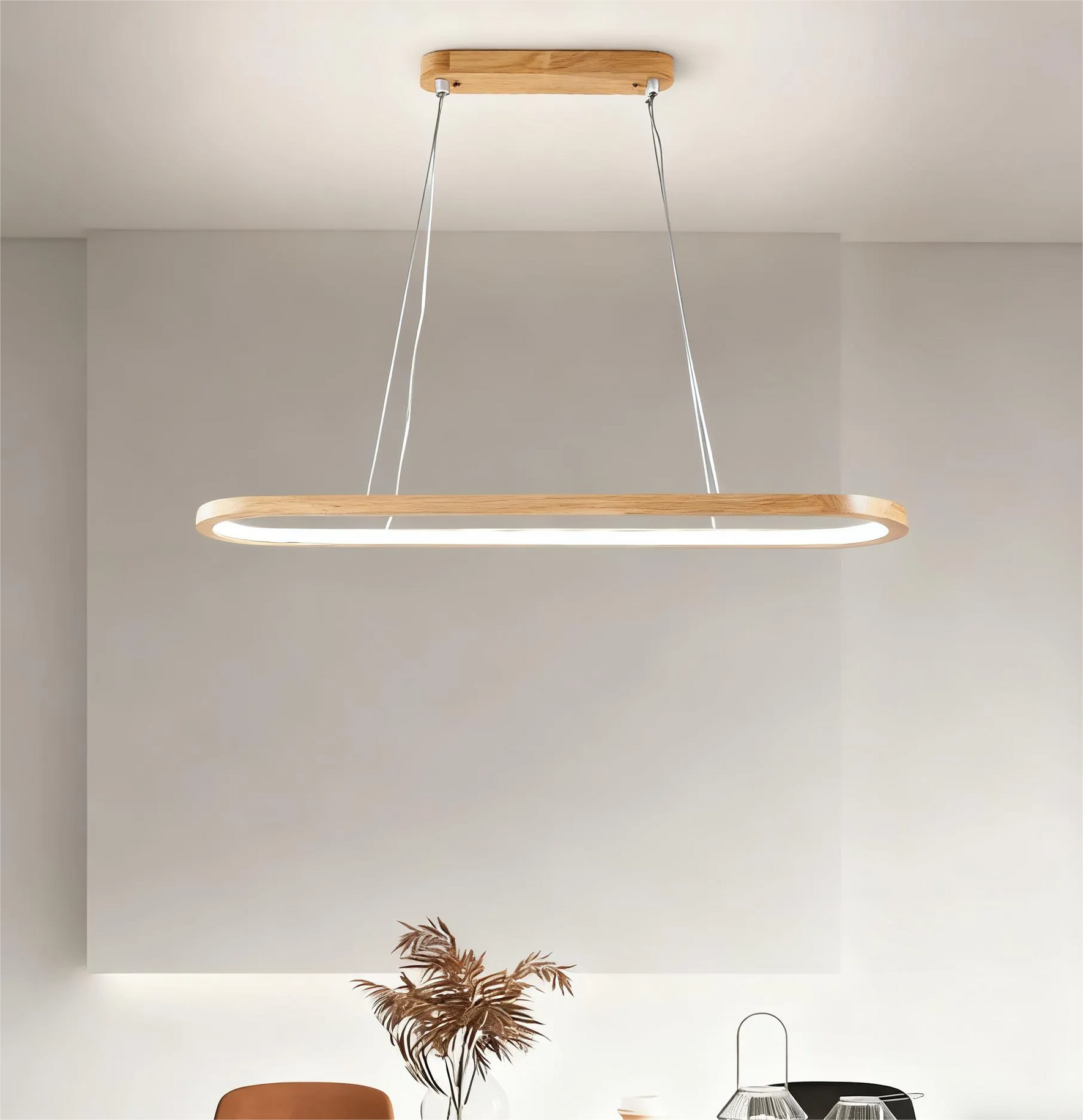 Wood oval pendant light above a dining table in an open-plan kitchen dining room