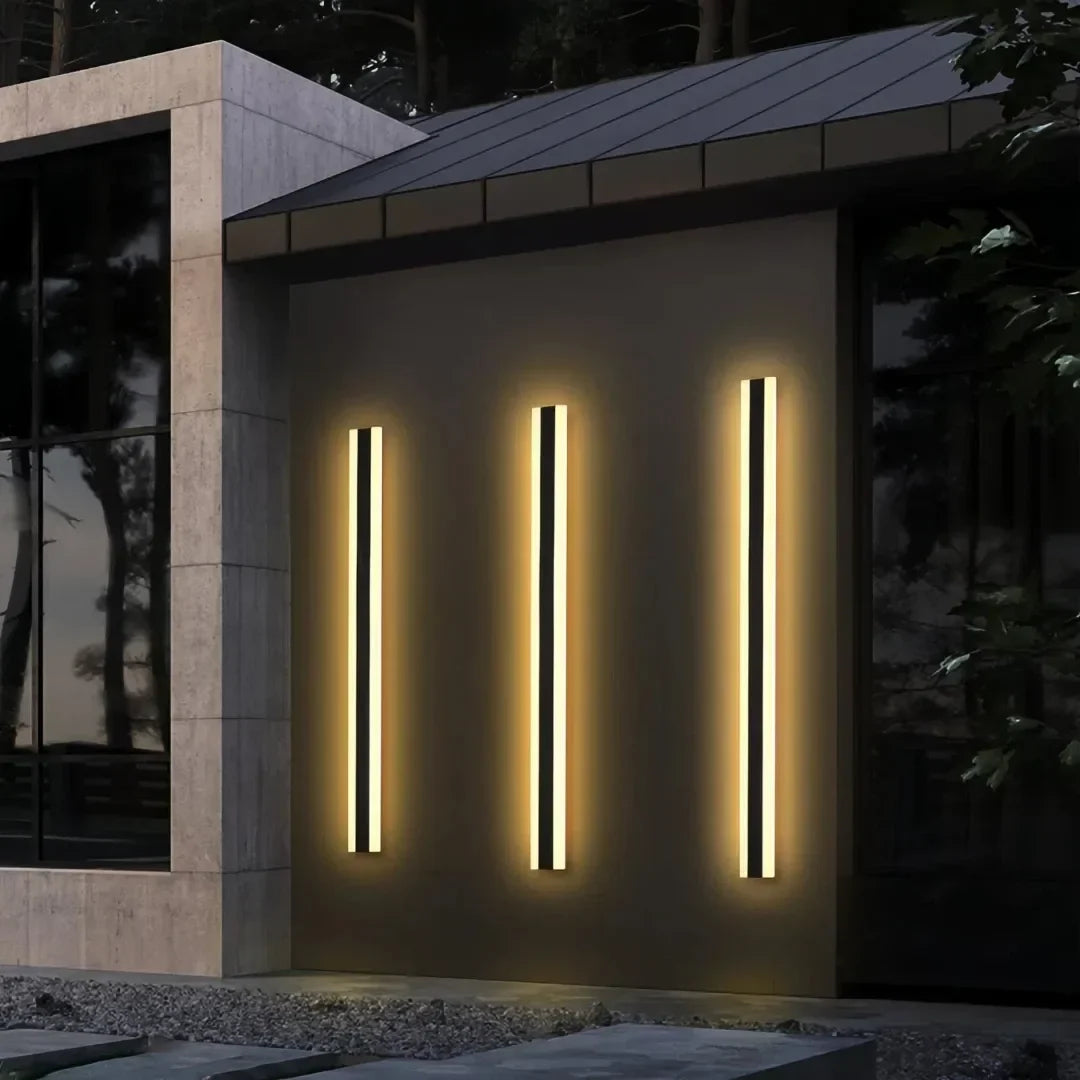 Two illuminated black linear wall lights on an exterior wall
