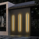Two illuminated black linear wall lights on an exterior wall