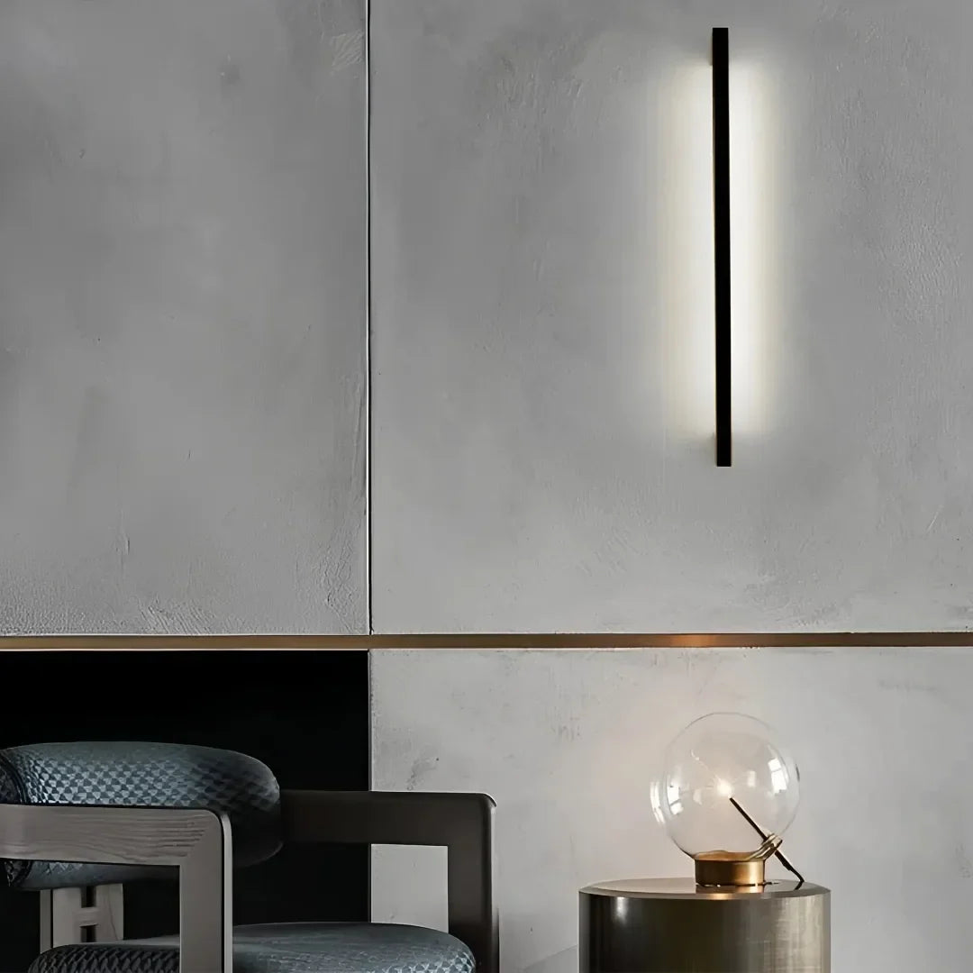 Black linear wall light creating soft indirect light in a modern living room