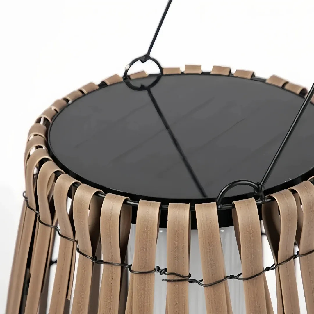 Close-up of the integrated solar panel and woven rattan frame on an outdoor floor lantern