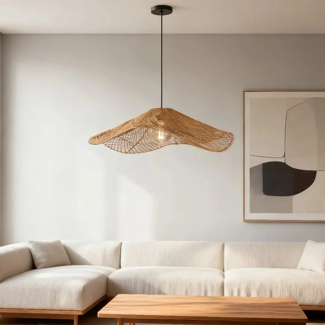 Single wave rattan pendant with a black round ceiling canopy above a sofa