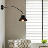 Industrial wall light mounted beside a bed for reading