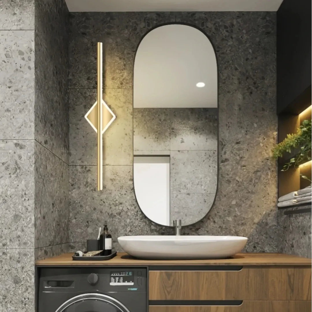 Gold square-detail linear LED bathroom mirror light above a round mirror