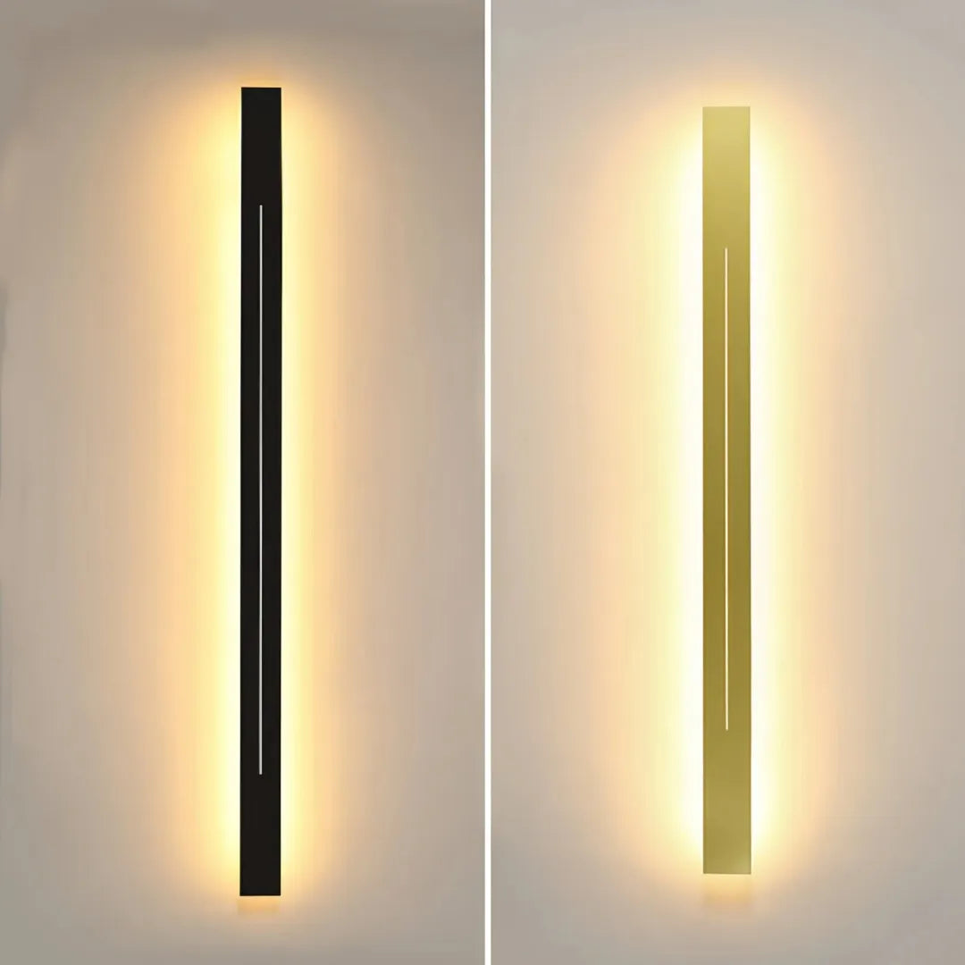 Black and gold linear LED wall lights casting warm light in a modern interior.