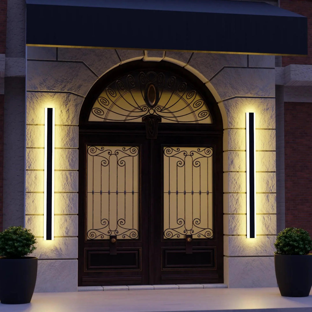 Two black vertical LED wall lights casting warm light beside an arched entrance