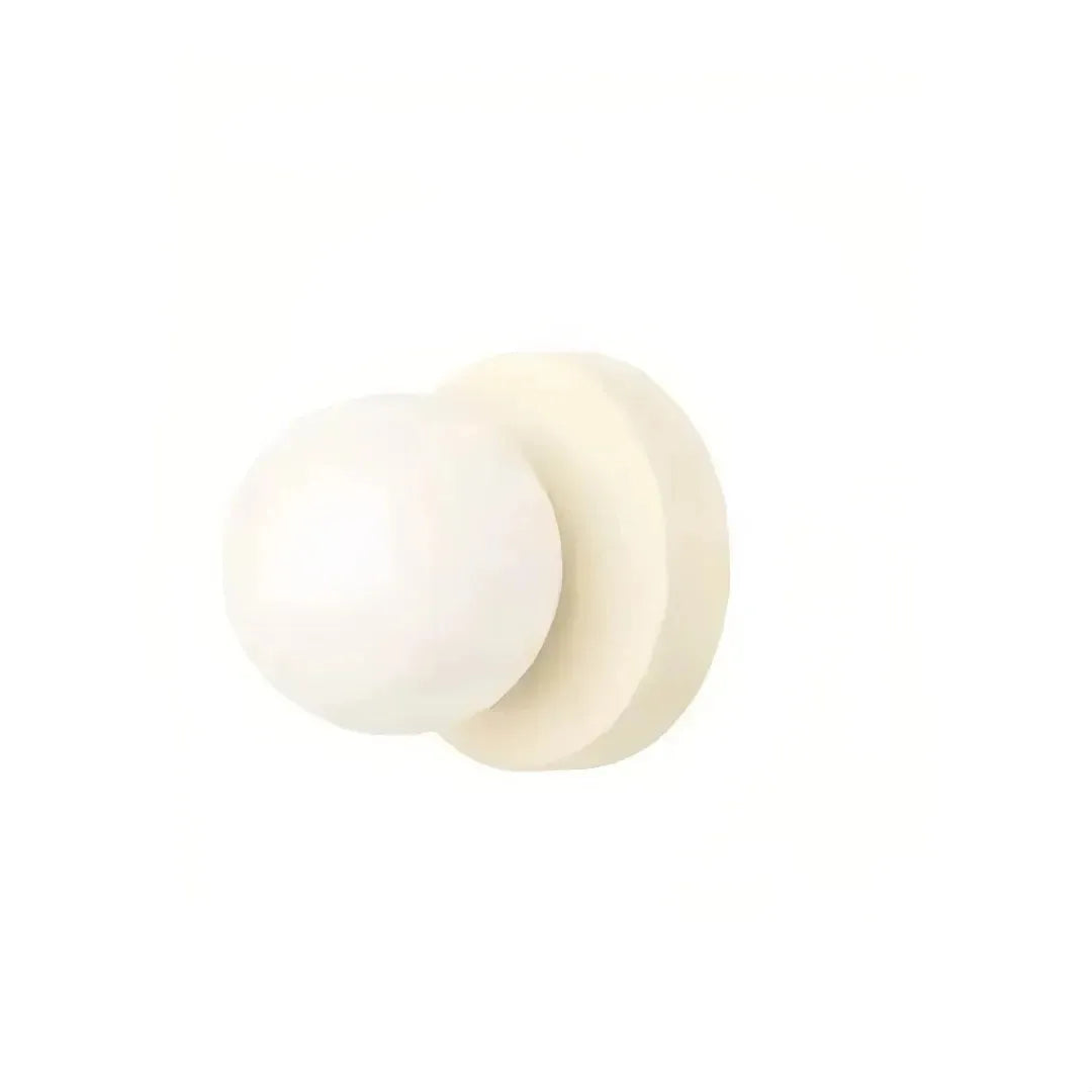 Illuminated glass globe wall light in a bedroom setting