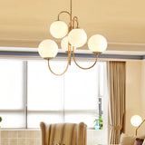 Illuminated six-globe chandelier beside a window and curtains